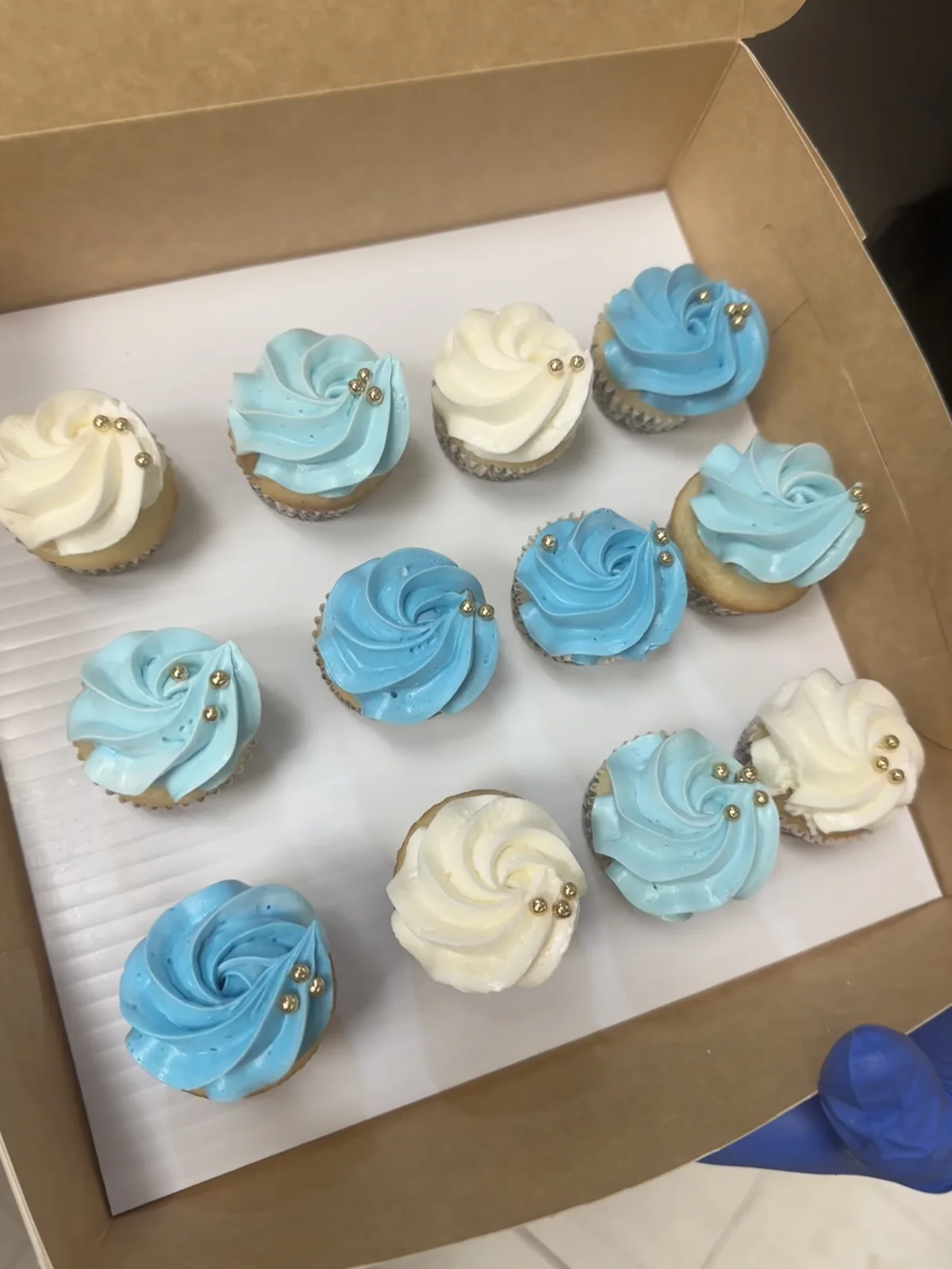 Blue and white decorated cupcakes for a baby shower