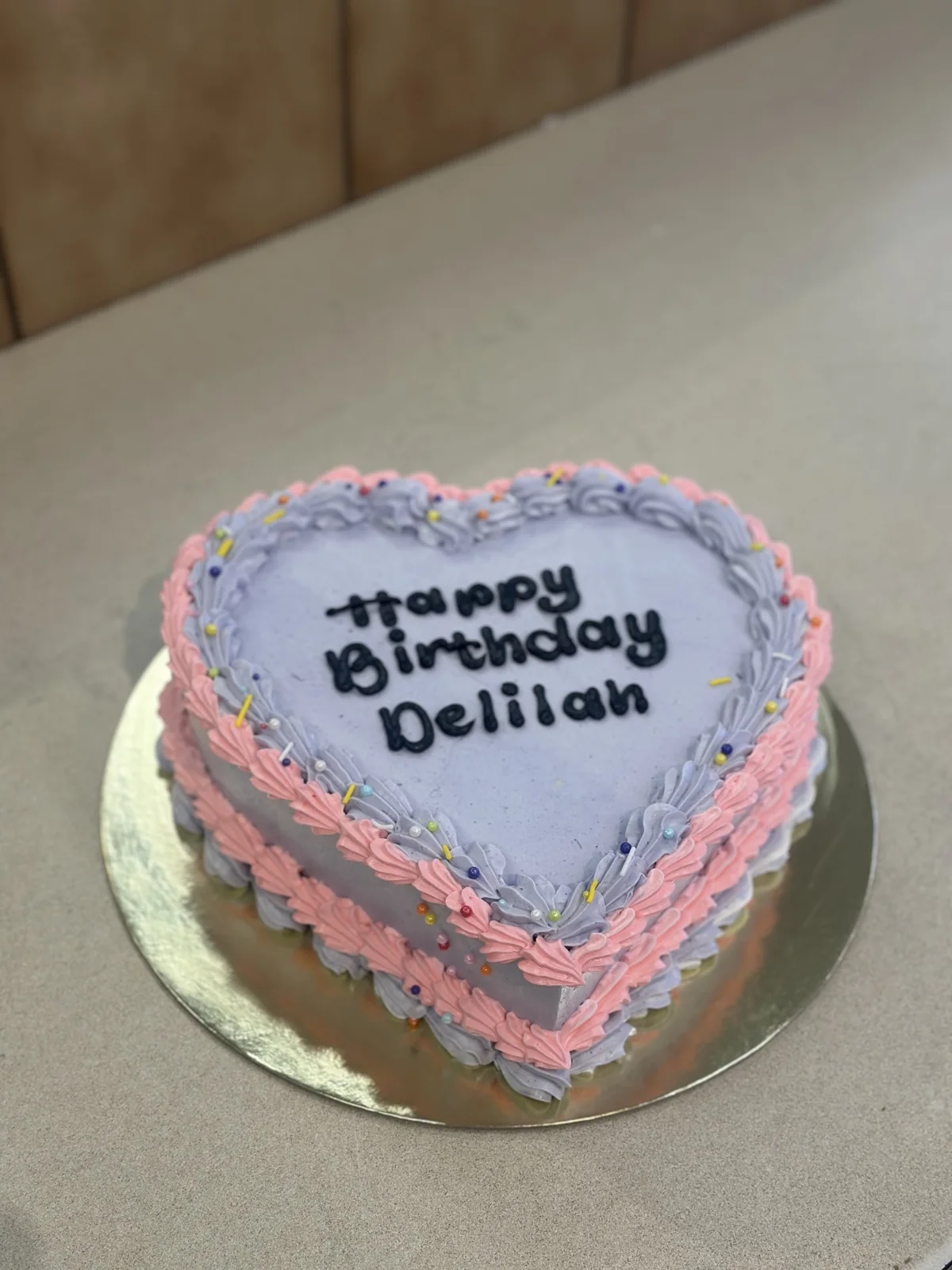 Pink and blue heart-shaped cake with piped border