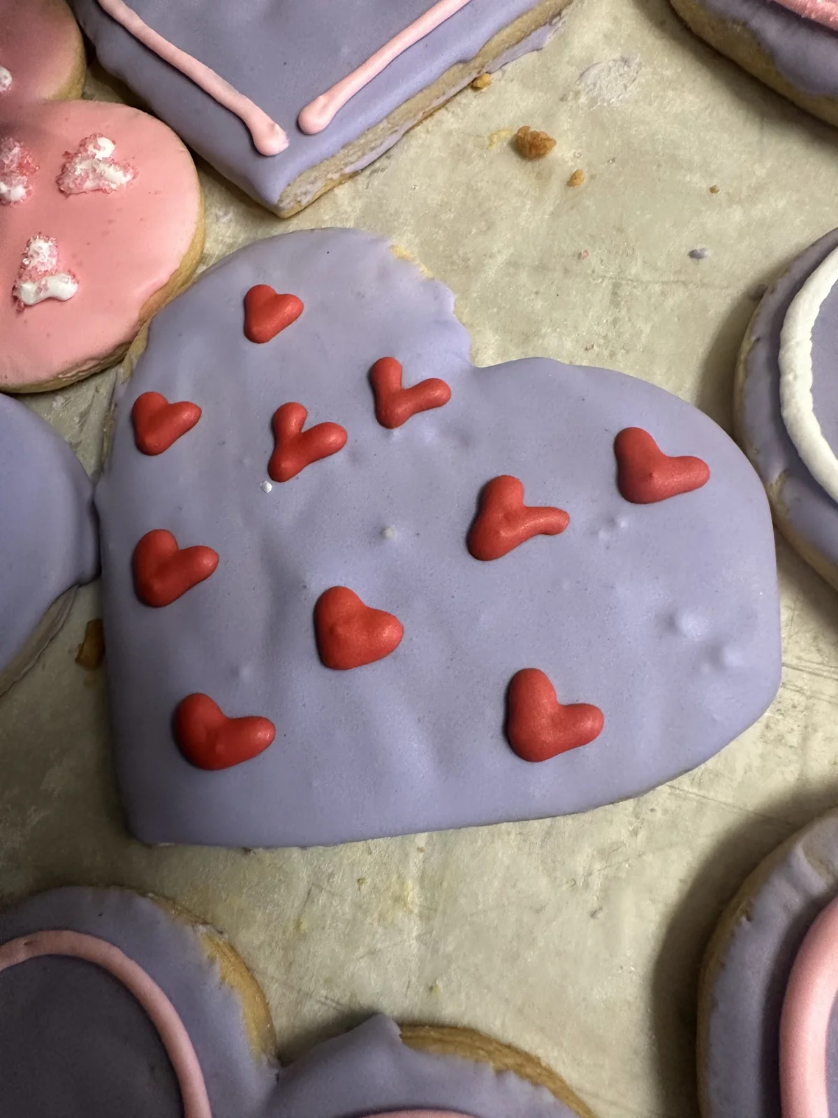 Hand-decorated heart cookie with piped red hearts