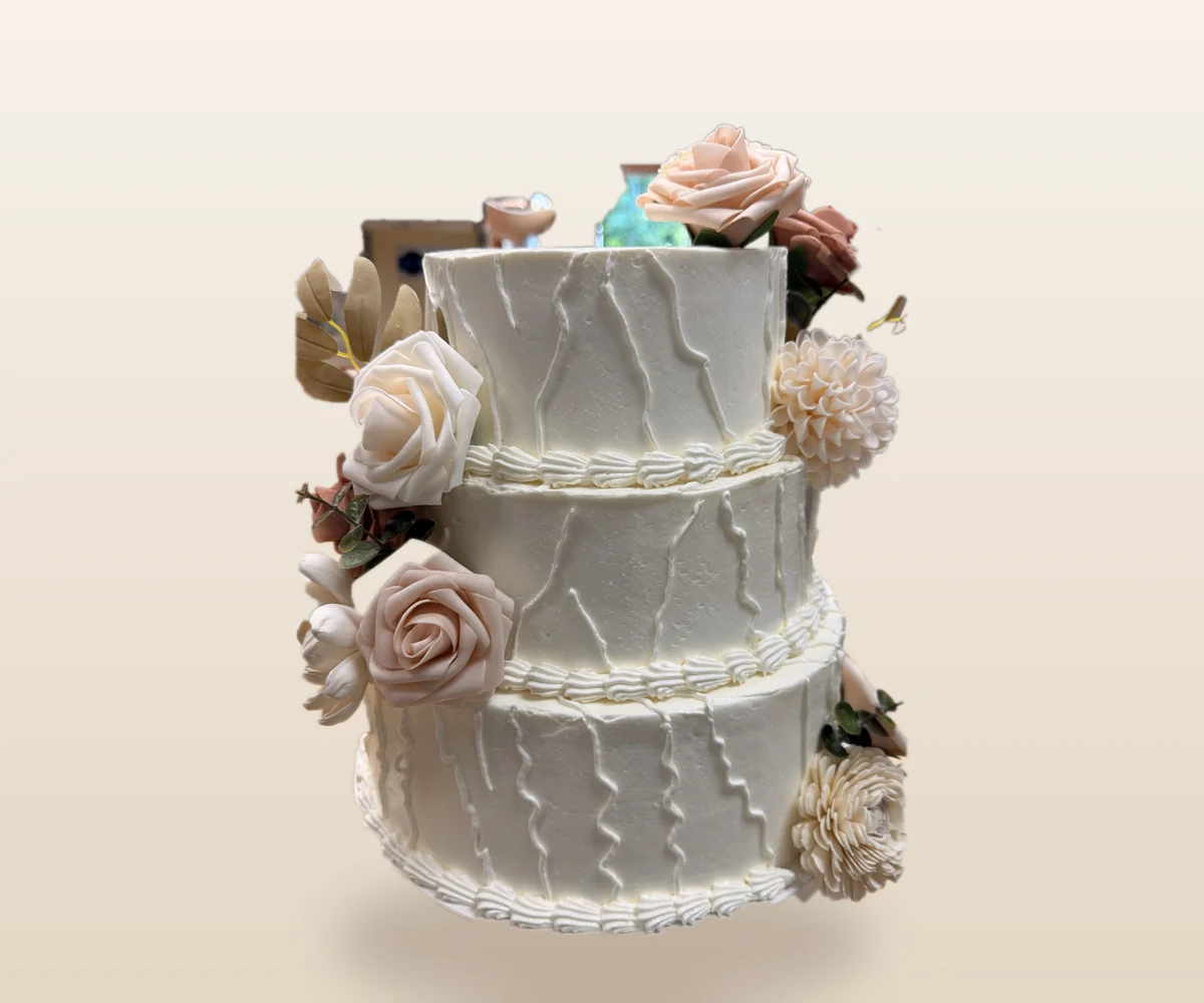 Three-tier white wedding cake with blush floral details by Richlea Bakery