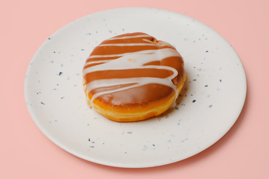 Nutella filled donut with maple glaze and white drizzle