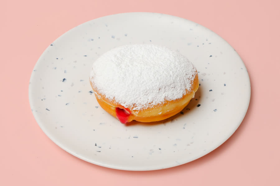 Raspberry filled donut dusted with icing sugar