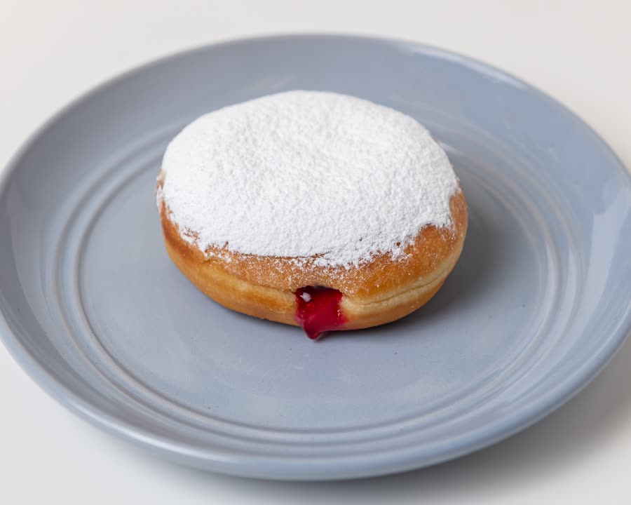 Strawberry filled donut dusted with icing sugar